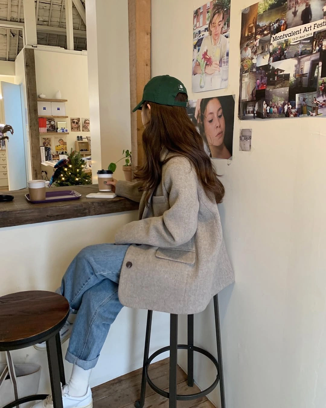 Light gray blazer, blue jeans, white sneakers, and green cap