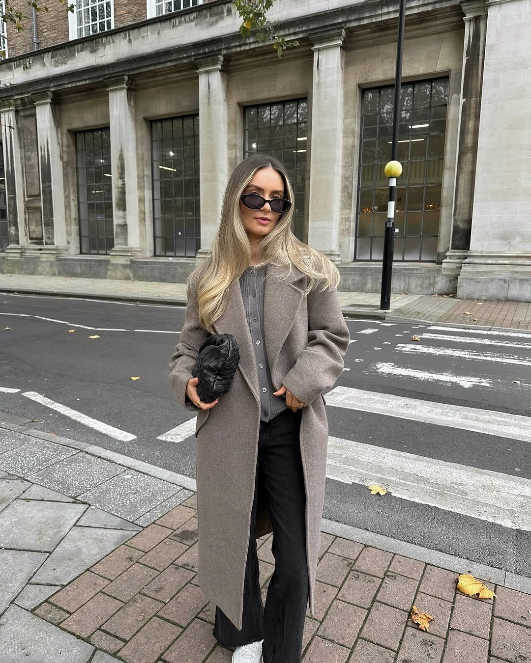 Taupe-gray long coat, gray top, black wide trousers, white shoes