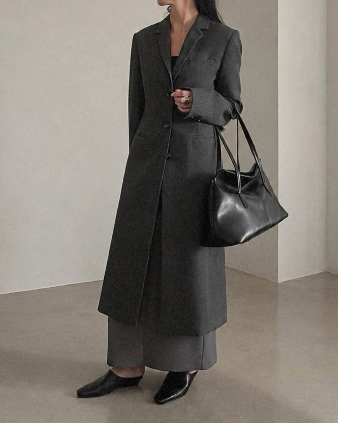 Dark gray long coat, wide gray trousers, black tote, pointed shoes