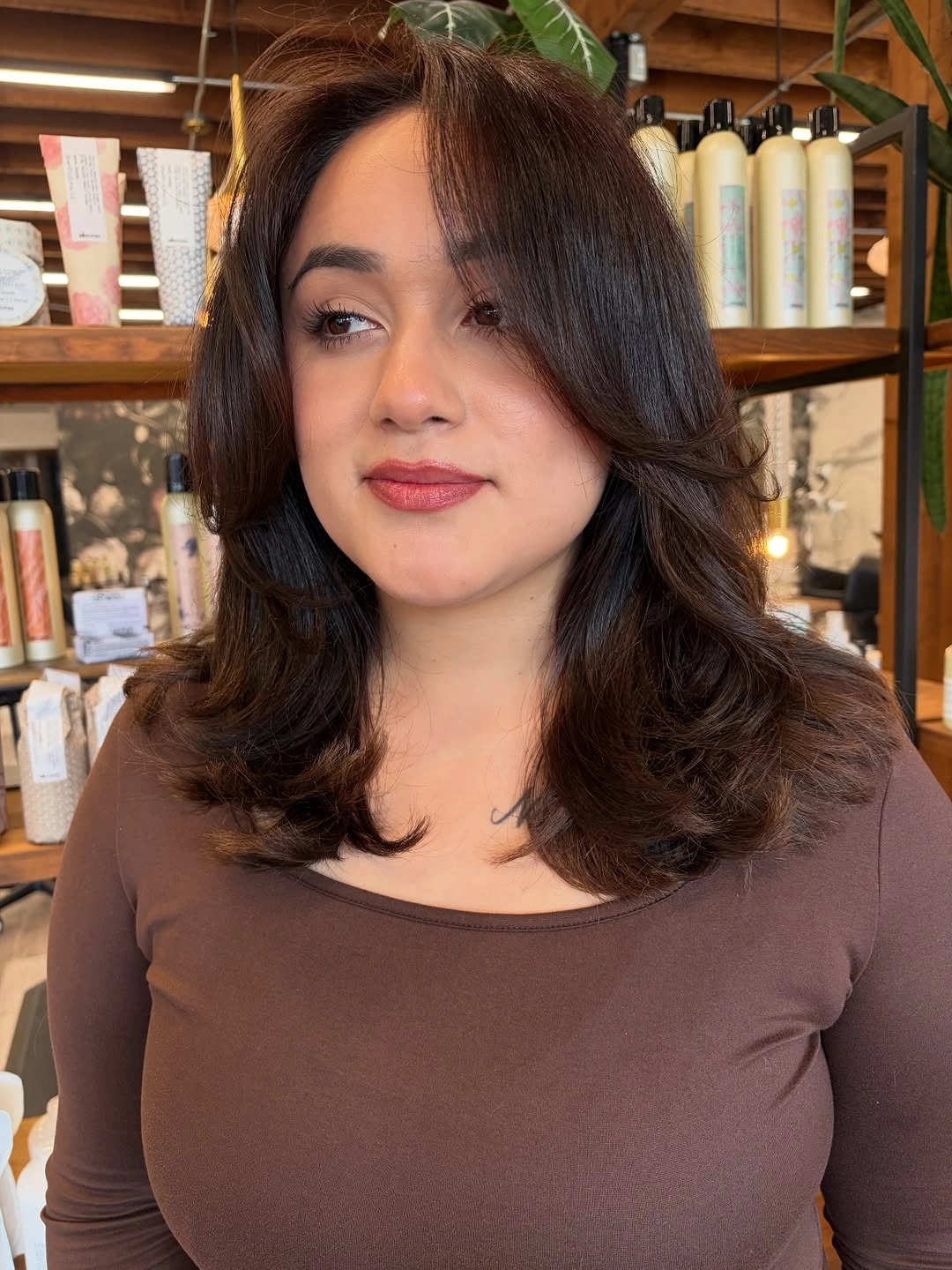 Shoulder-length dark layers with center-parted curtain bangs