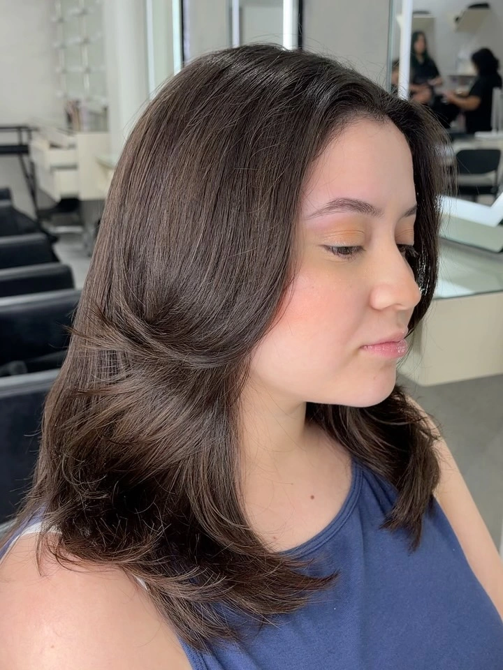 Shoulder-length dark hair with long curved front layers