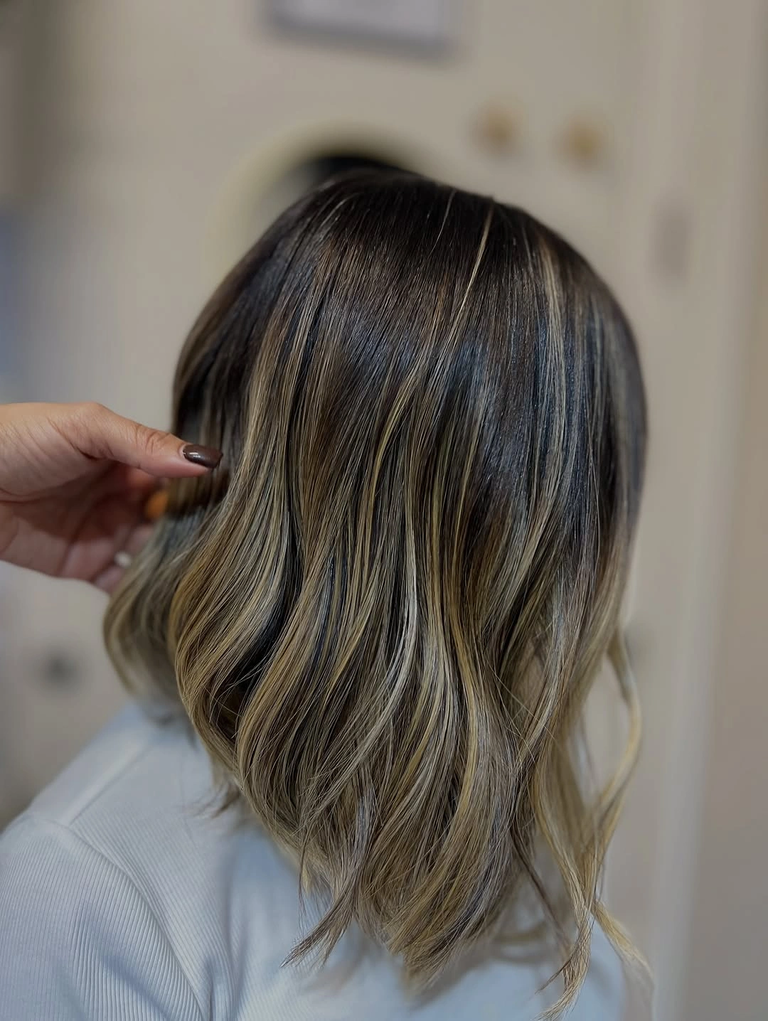 Medium-length wavy hair with lighter strands and long front pieces