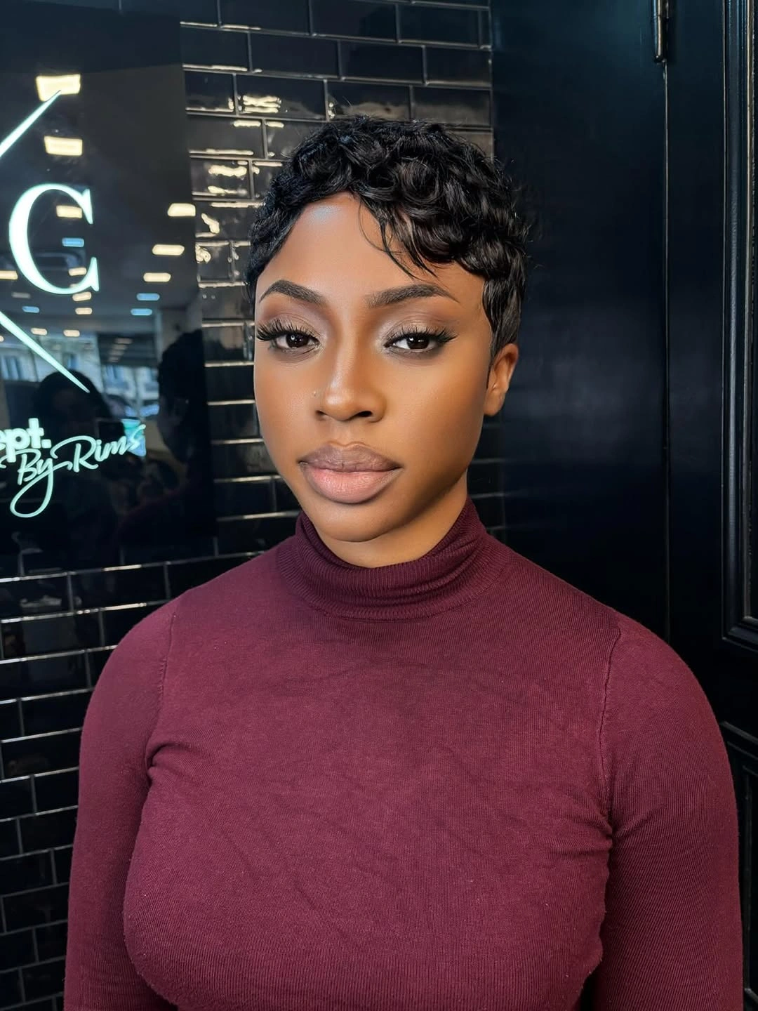 Short dark pixie with curled textured top and close sides