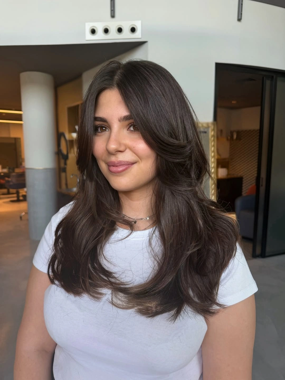 Long dark layered hair with center-parted front pieces