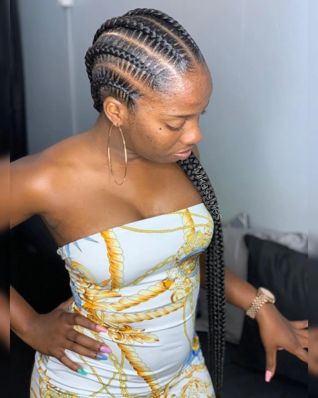 Dark scalp braids with curved partings and long lengths over one shoulder