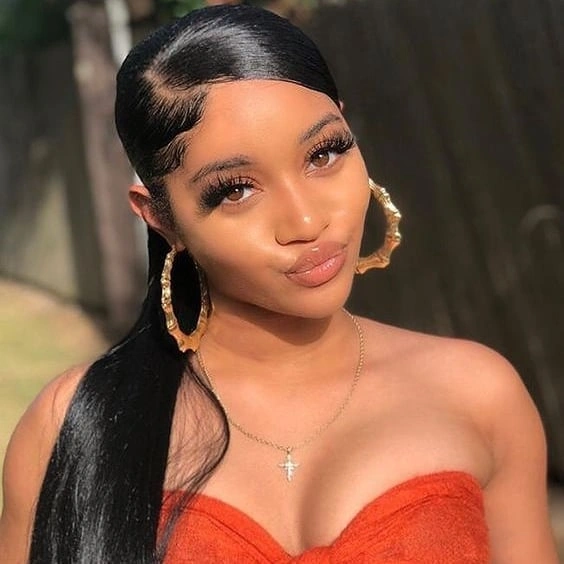Smooth dark ponytail over one shoulder with a deep curved side part