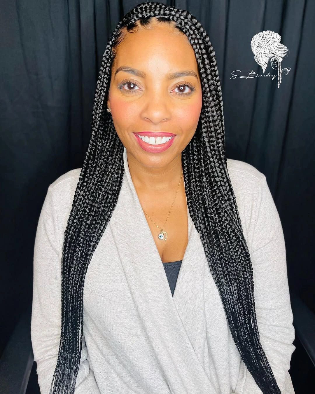 Long dark individual braids falling in two groups from small visible root sections