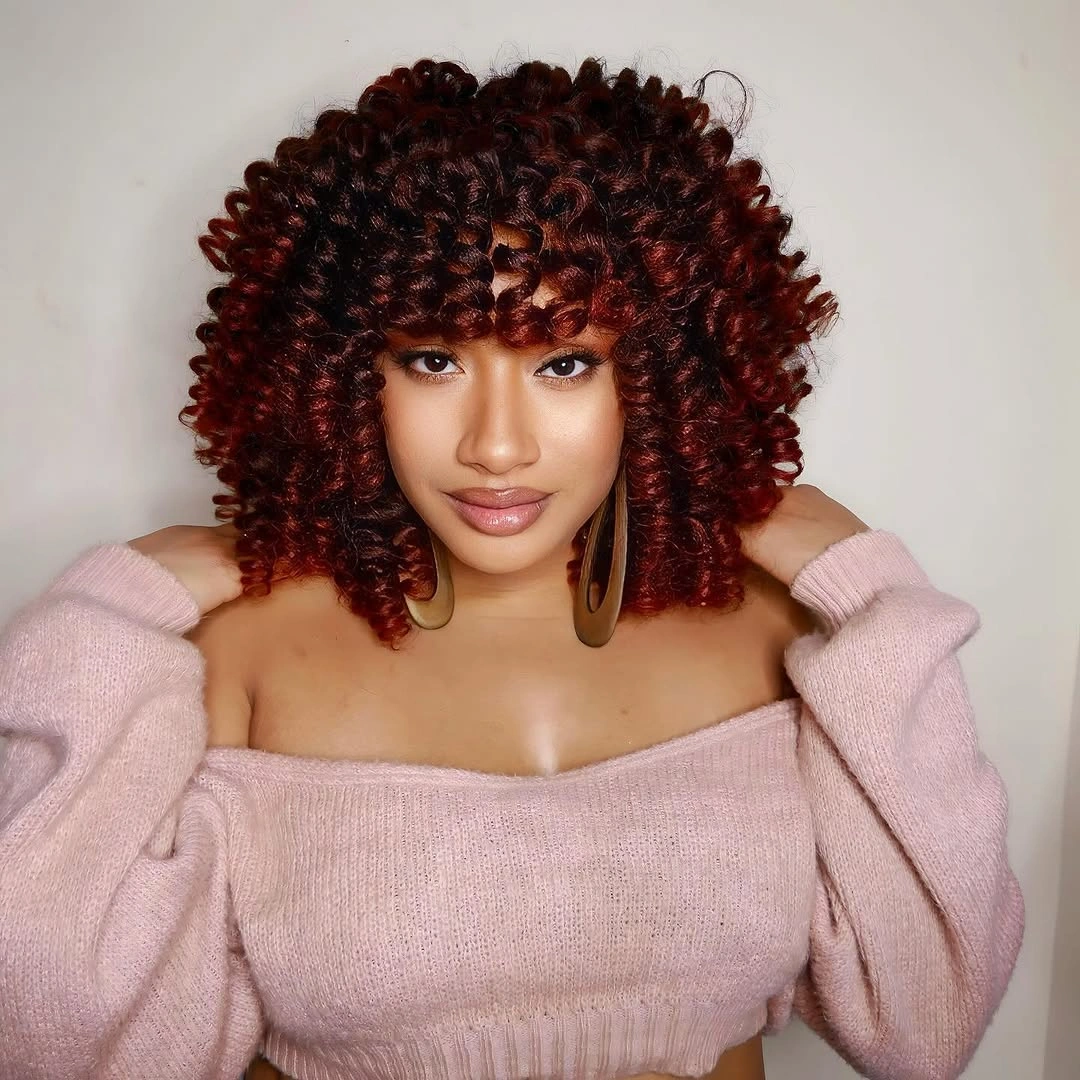 Rounded auburn curls with a spiral fringe and shoulder-grazing sides
