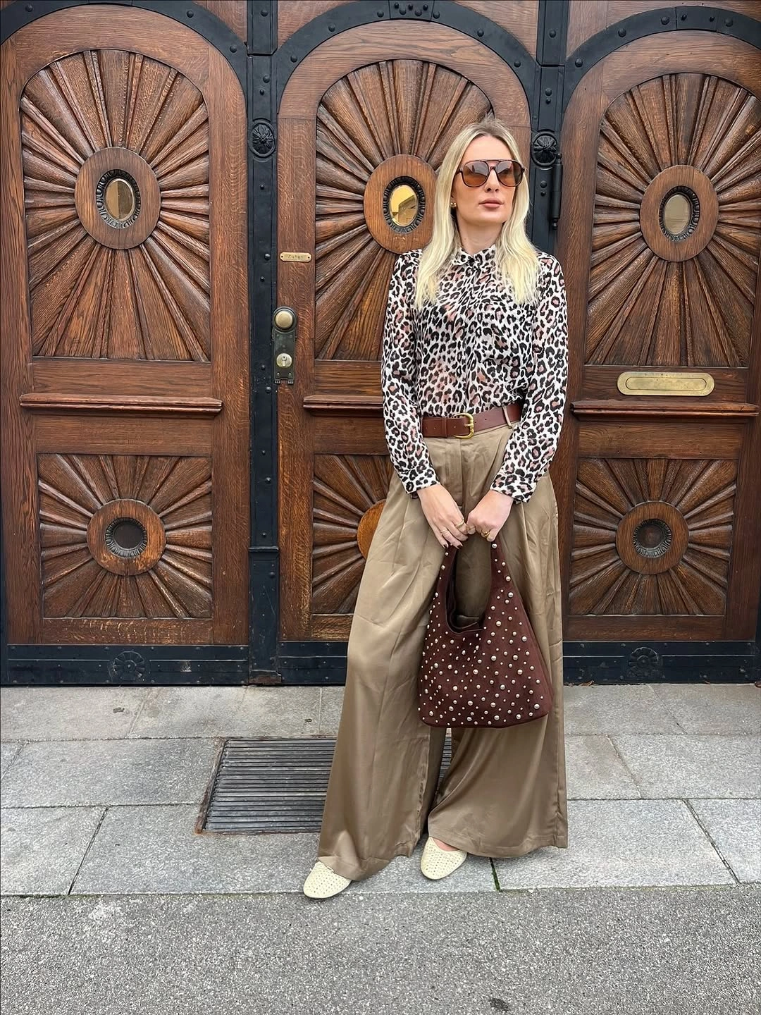 Leopard-print blouse, beige wide trousers, brown belt, and dotted brown bag