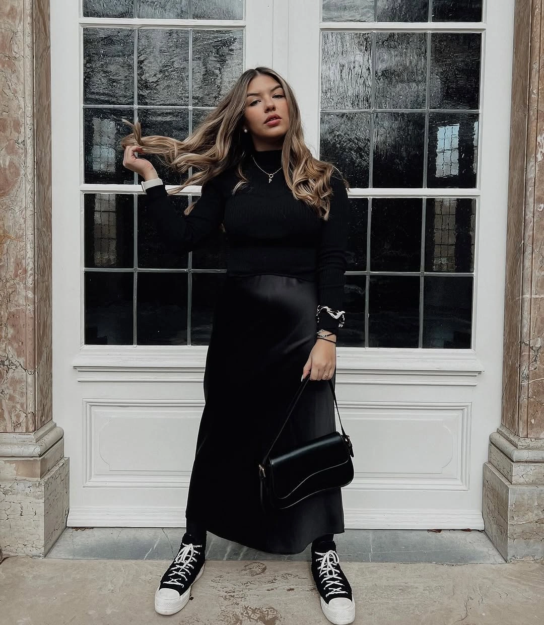 Long black outfit with black bag and black-and-white high-top sneakers
