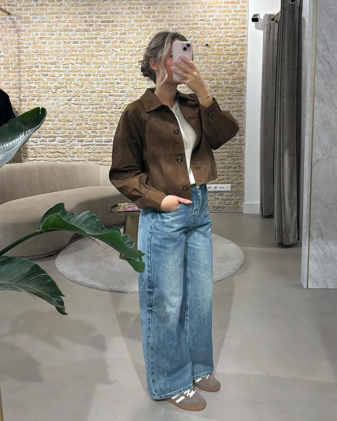 Cropped brown jacket, white top, light blue wide-leg jeans, and taupe shoes