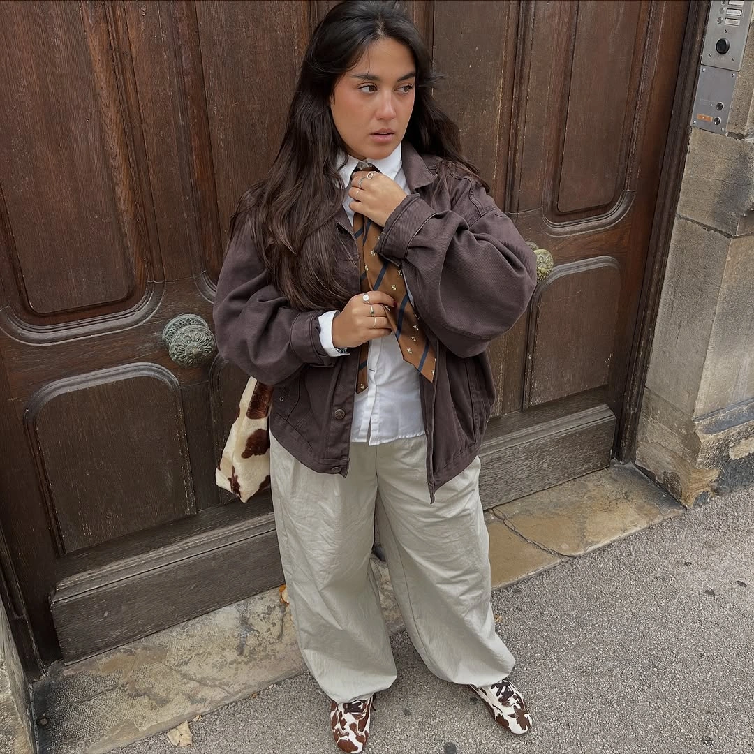 Oversized brown jacket, white shirt, cream pants, and patterned shoes