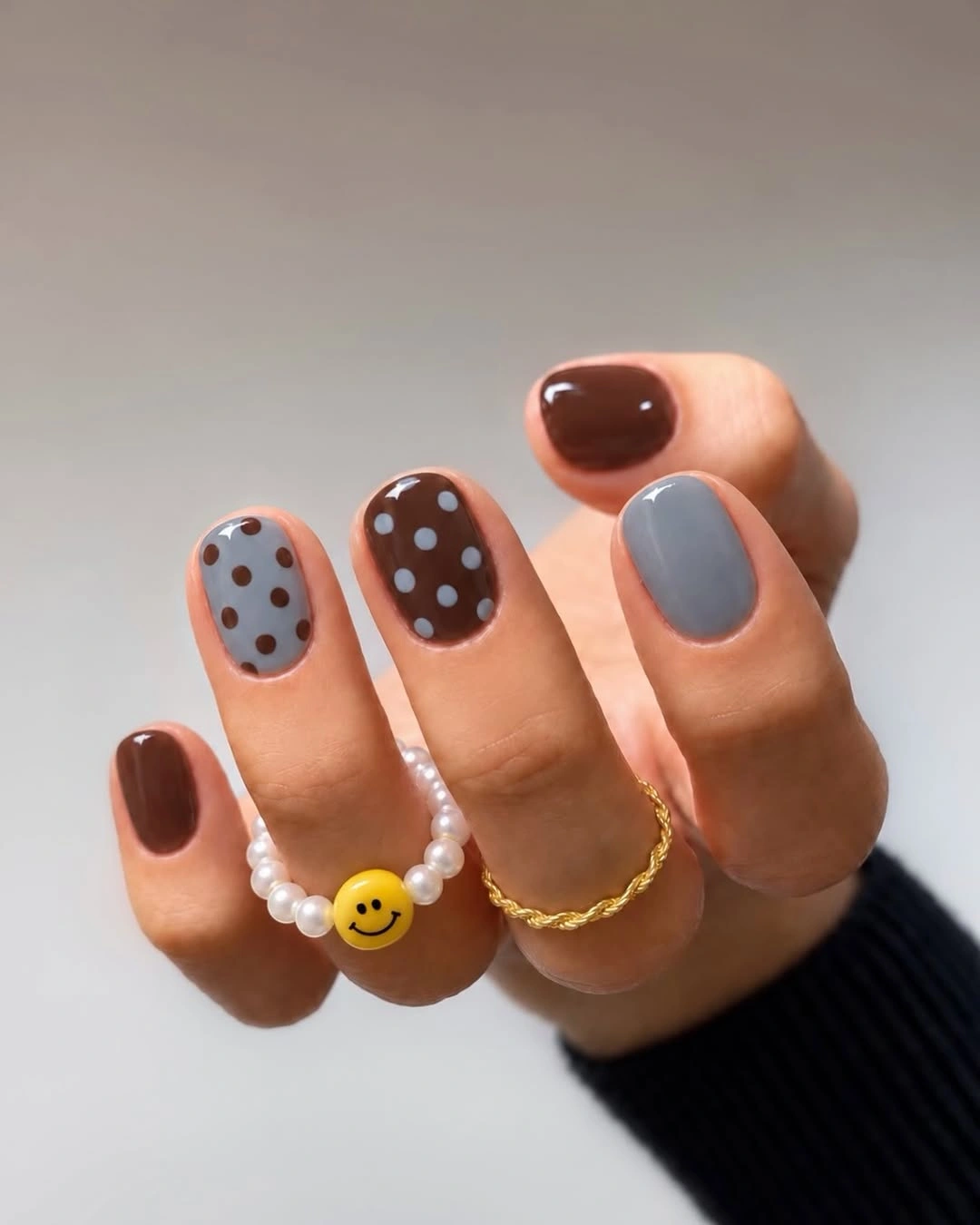 Very short nails with brown, blue-gray and dotted polish