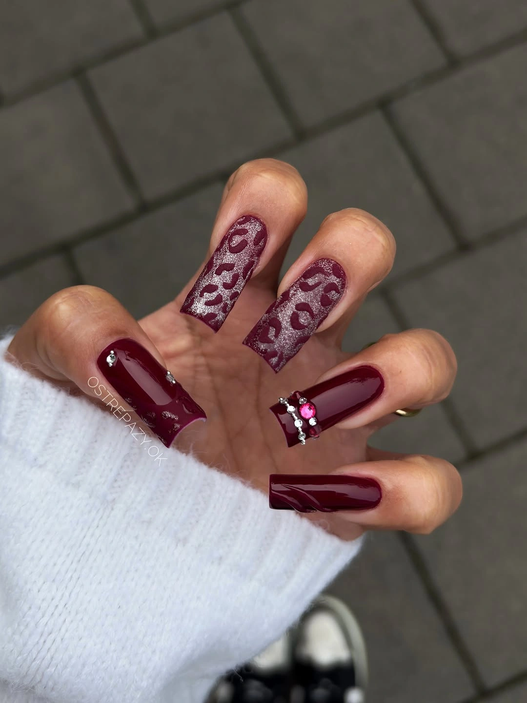 Long burgundy coffin nails with leopard-like glitter accent nails