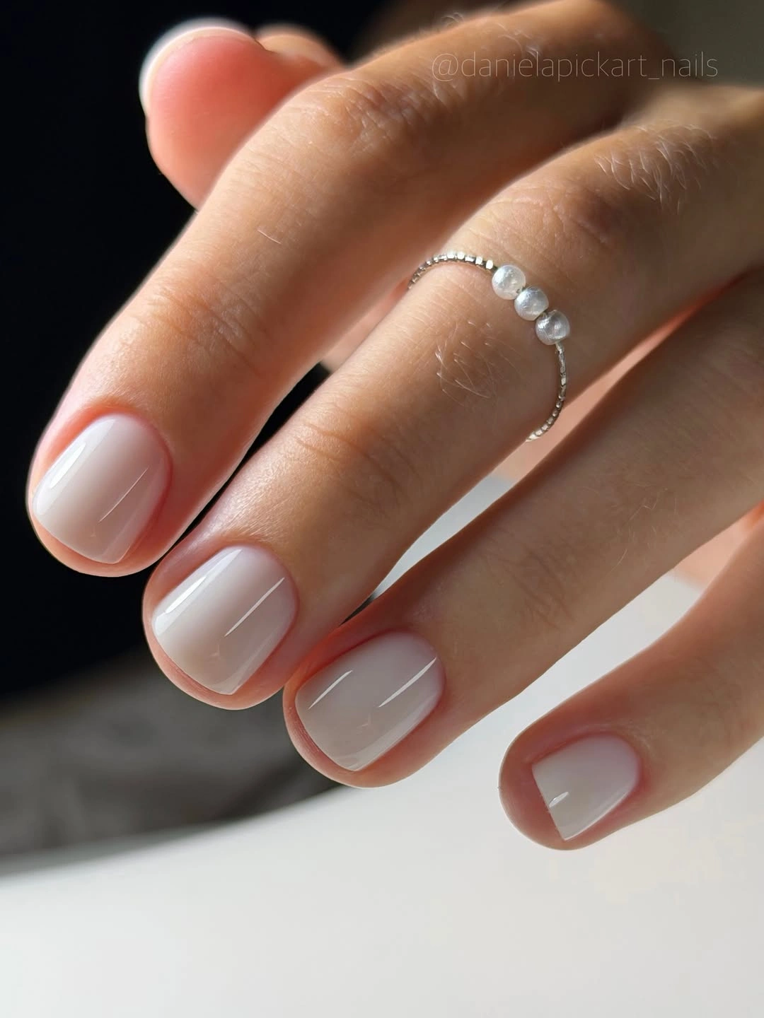 Short rounded-square nails with sheer milky pink-white polish