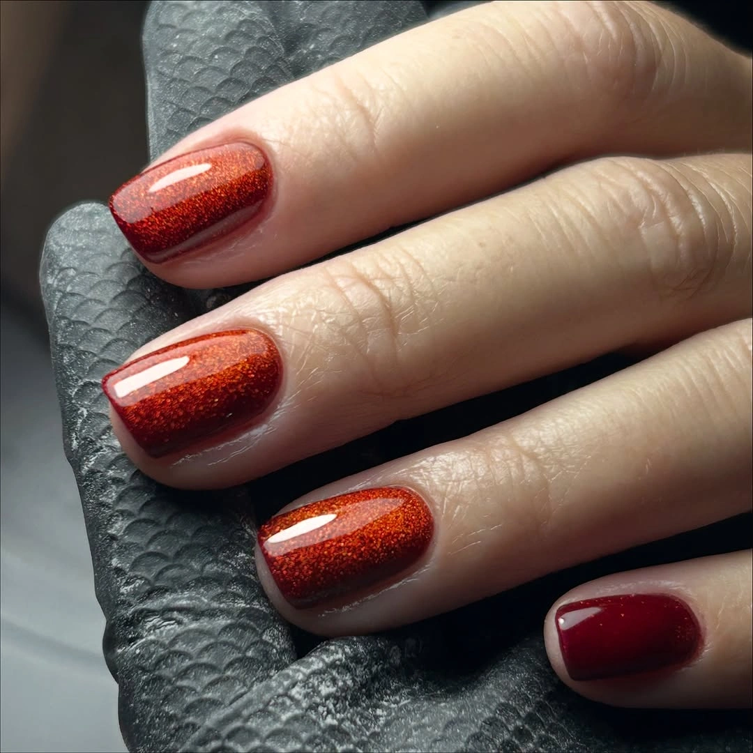 Short square nails with red shimmer and burgundy accent