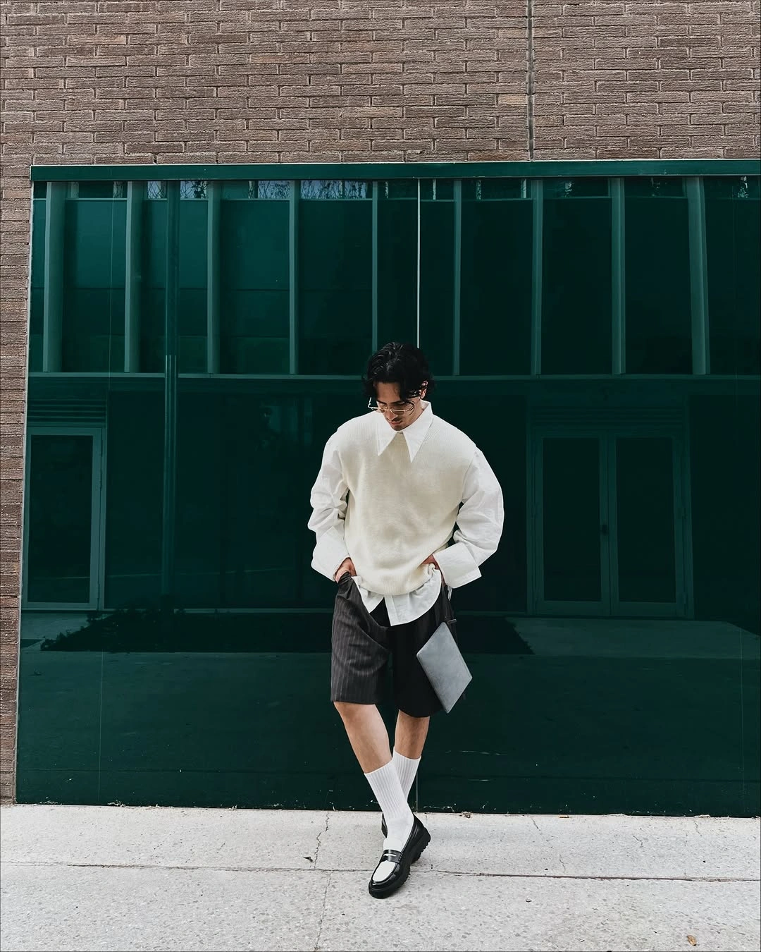 Cream knit top, dark shorts, white socks, and black loafers