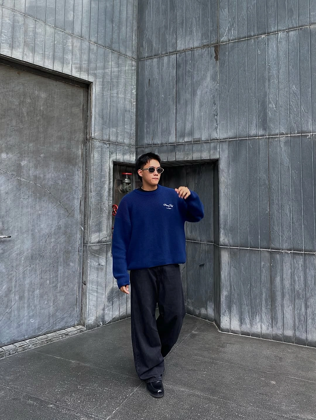 Royal-blue sweatshirt with wide charcoal trousers and dark shoes