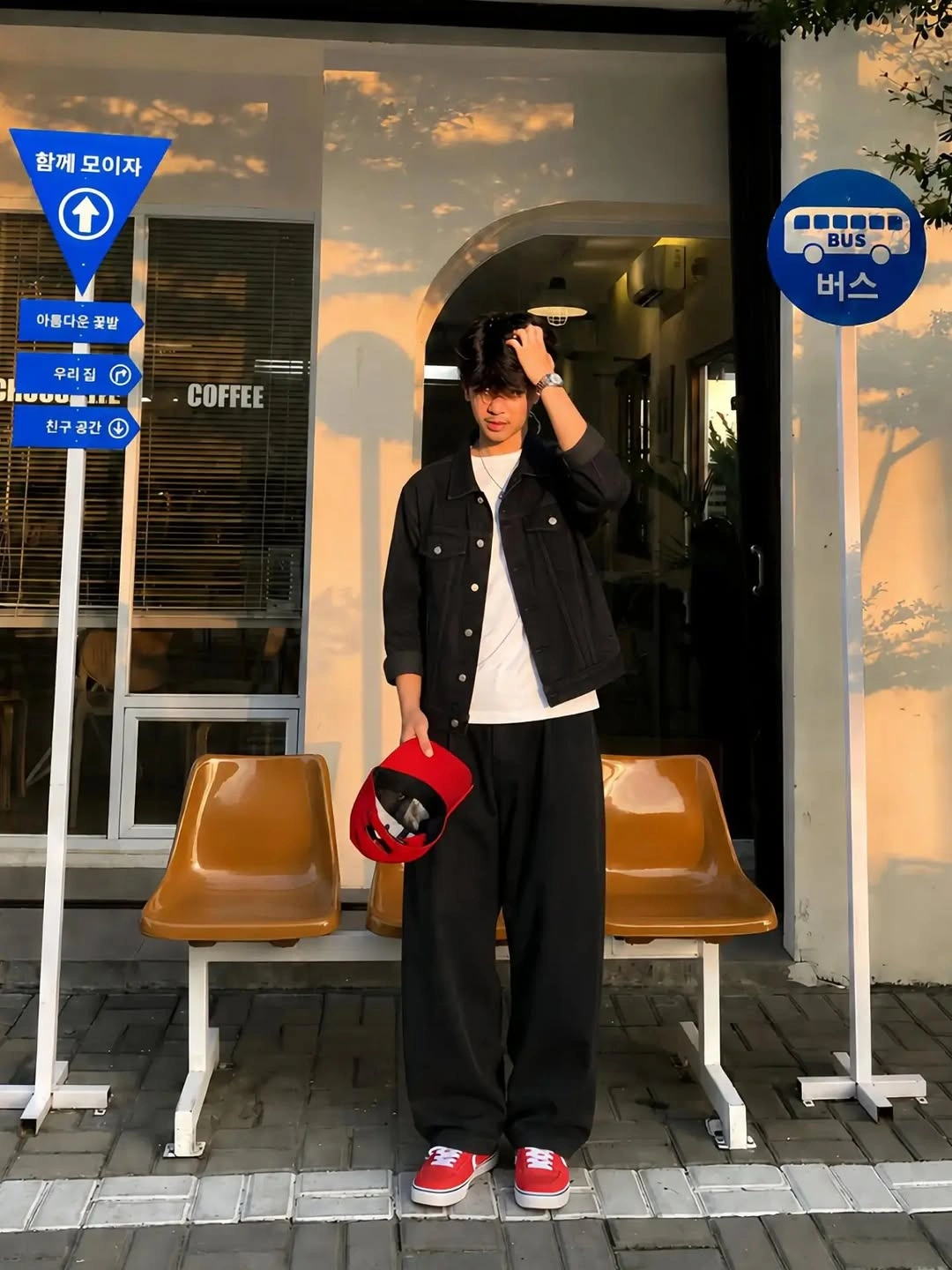 Black jacket and wide trousers with red sneakers and matching cap