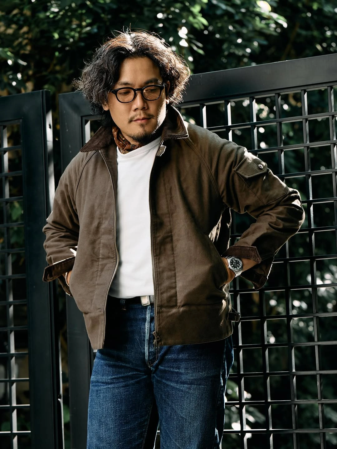 Olive bomber jacket over white T-shirt with blue jeans