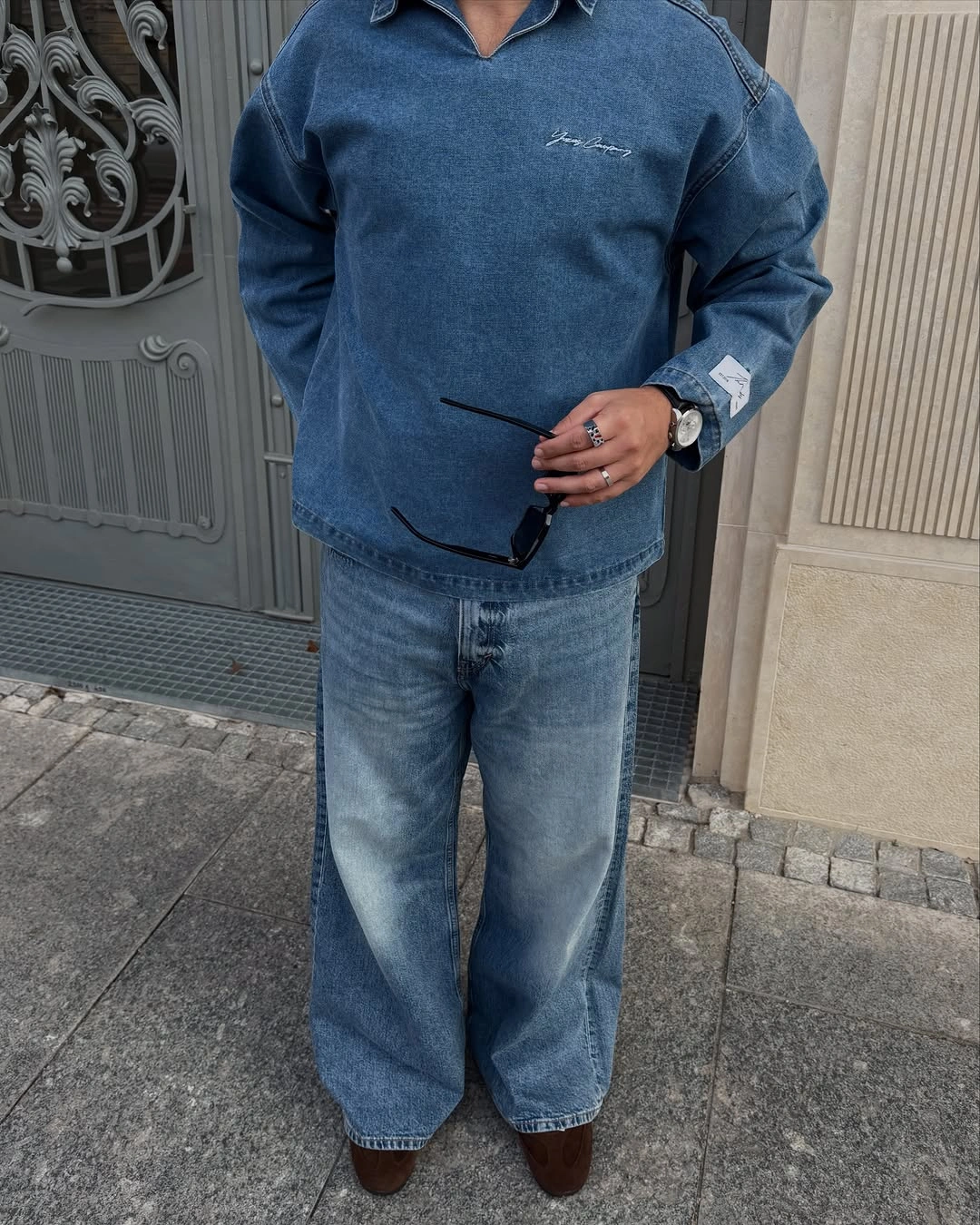 Deep blue sweatshirt with loose pale jeans and dark shoes