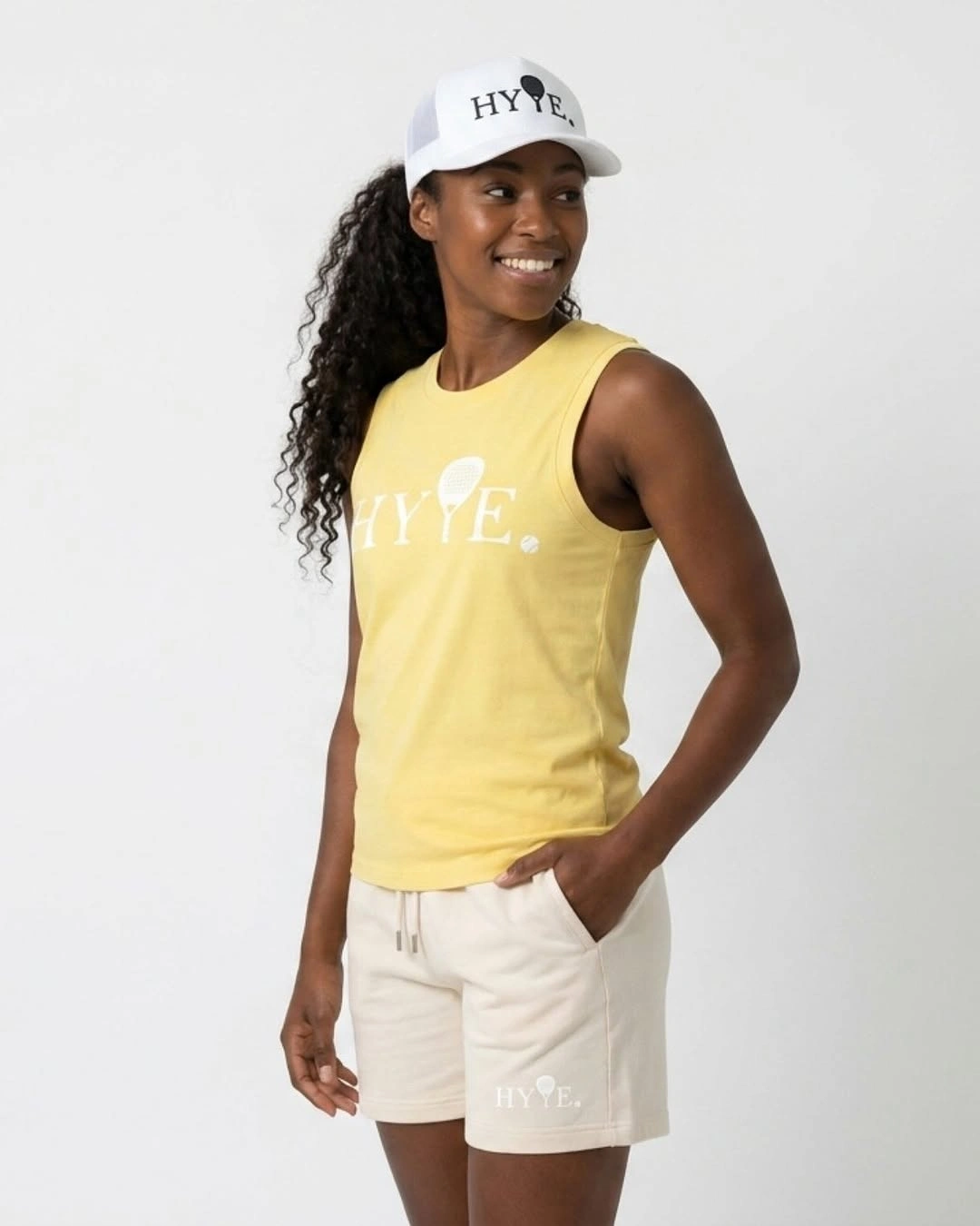 Yellow sleeveless tank and beige shorts for women’s padel
