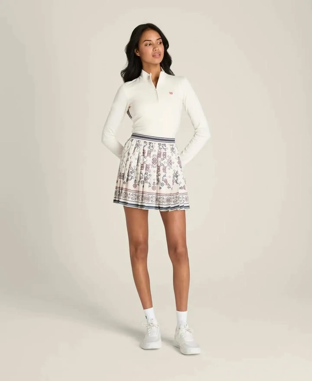 White zip top and printed skirt for a women’s padel outfit