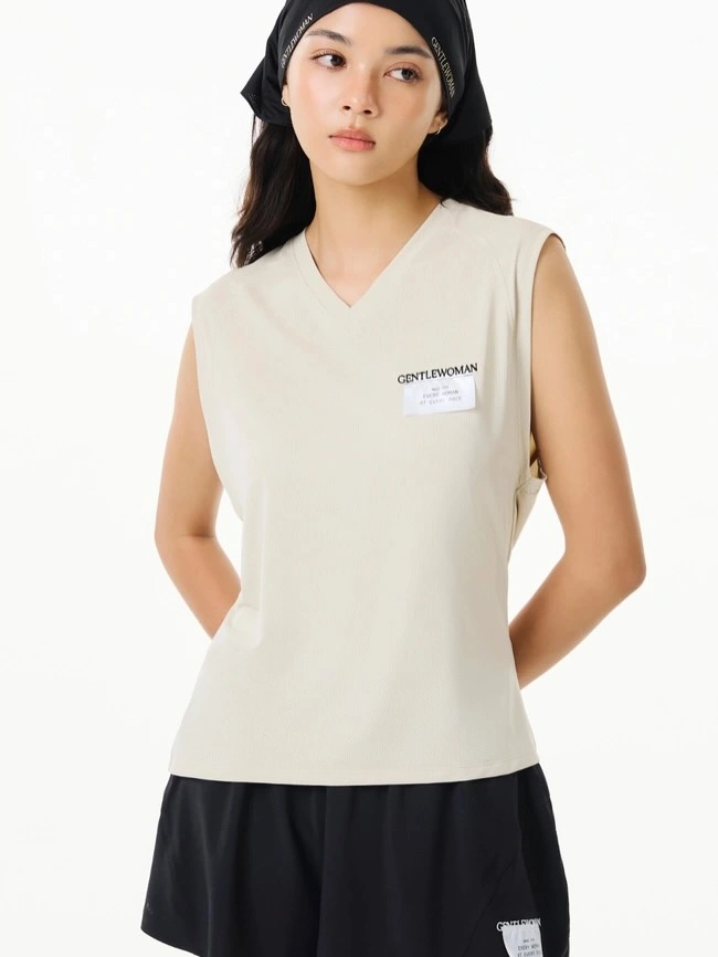 Cream sleeveless V-neck top with black shorts for women’s padel