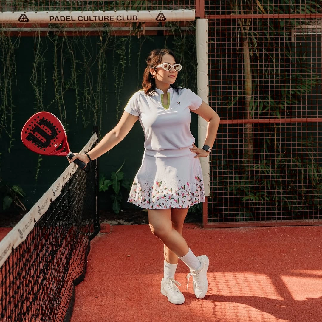 White polo and patterned pleated skirt for women’s padel outfit