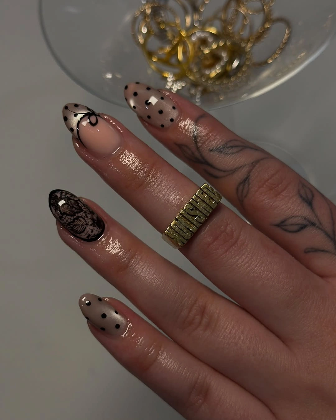Long nude nails with dark dotted sheer-looking tips and fine black line accent