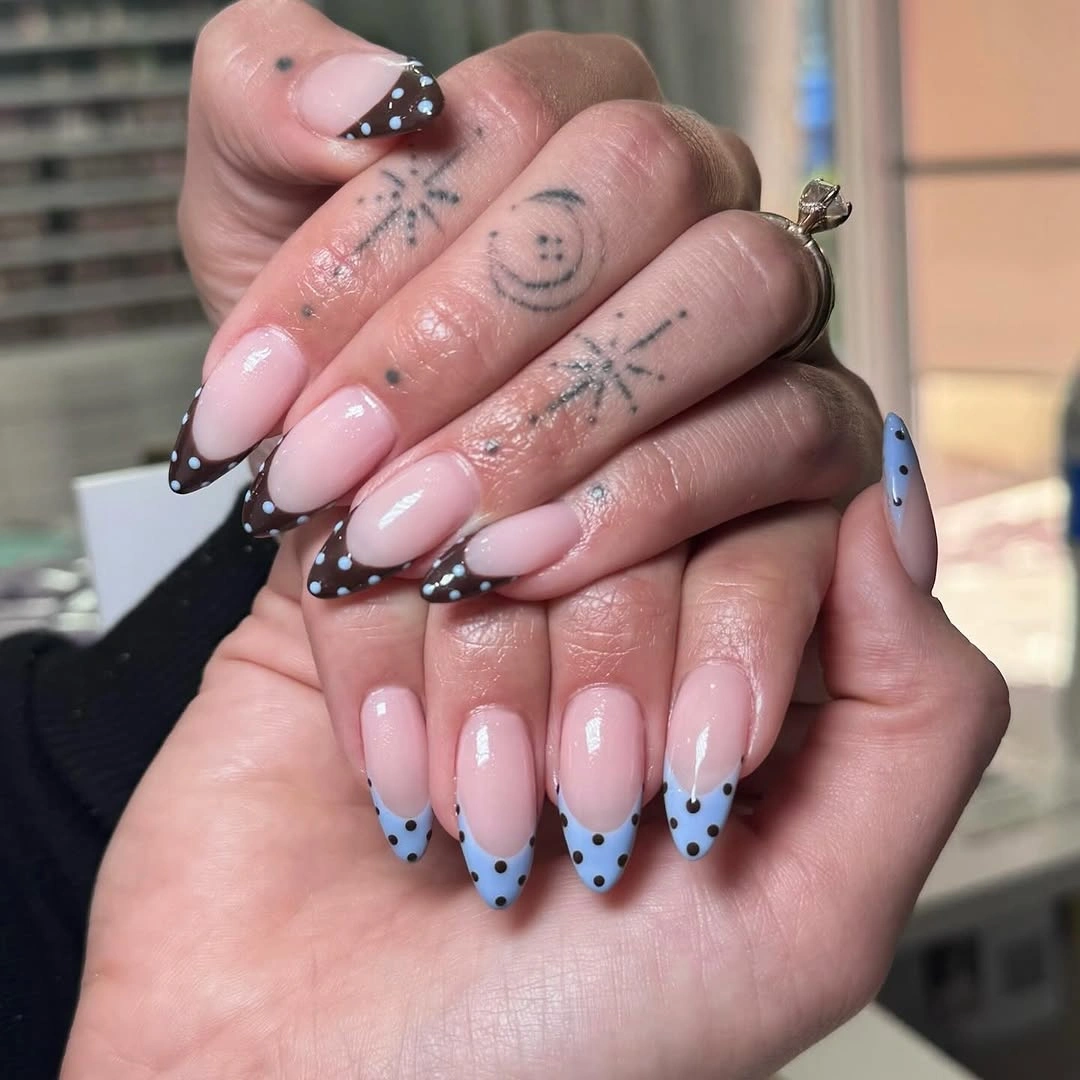 Long pale pink nails with black dotted French tips and subtle cool accent