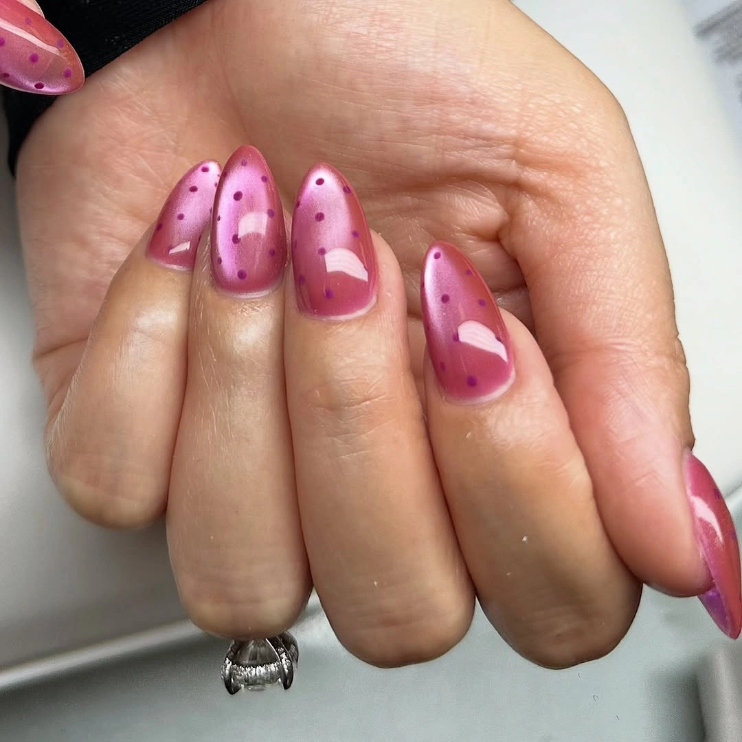 Medium pink almond nails with freeform magenta dot clusters and curved accents