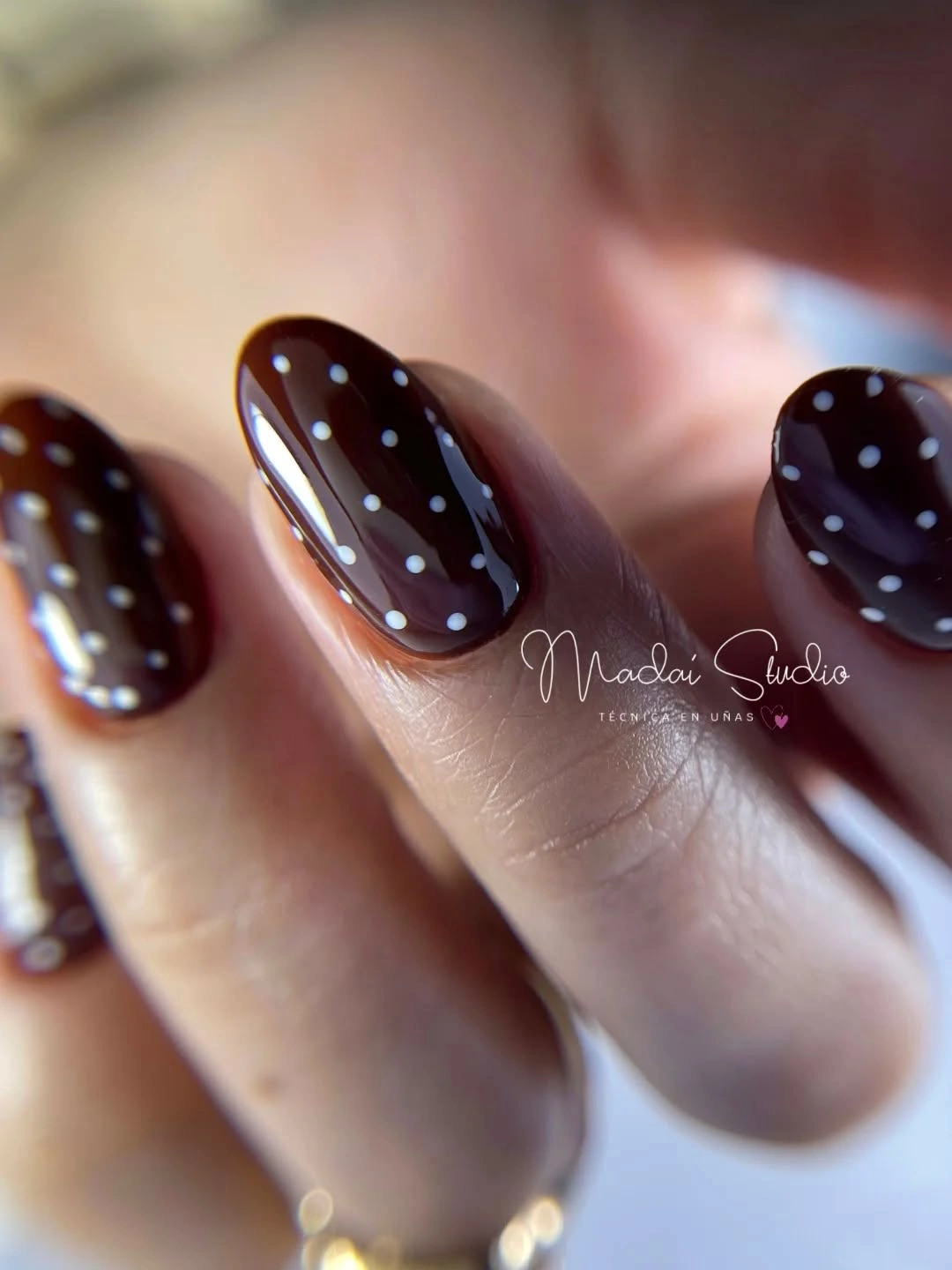 Short glossy chocolate brown rounded nails with tiny pale micro dots