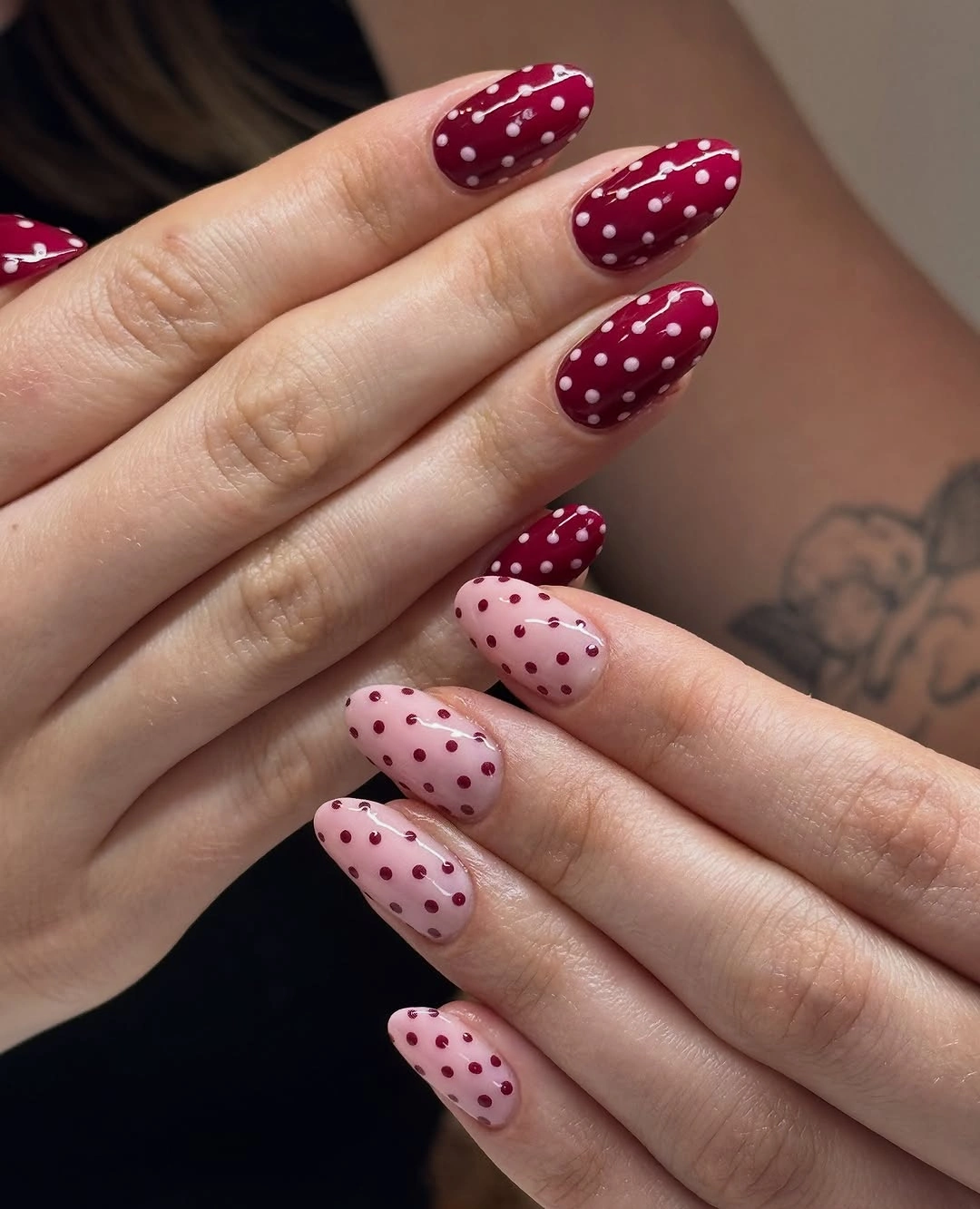 Long almond burgundy and pale pink nails with reversed white and burgundy dots