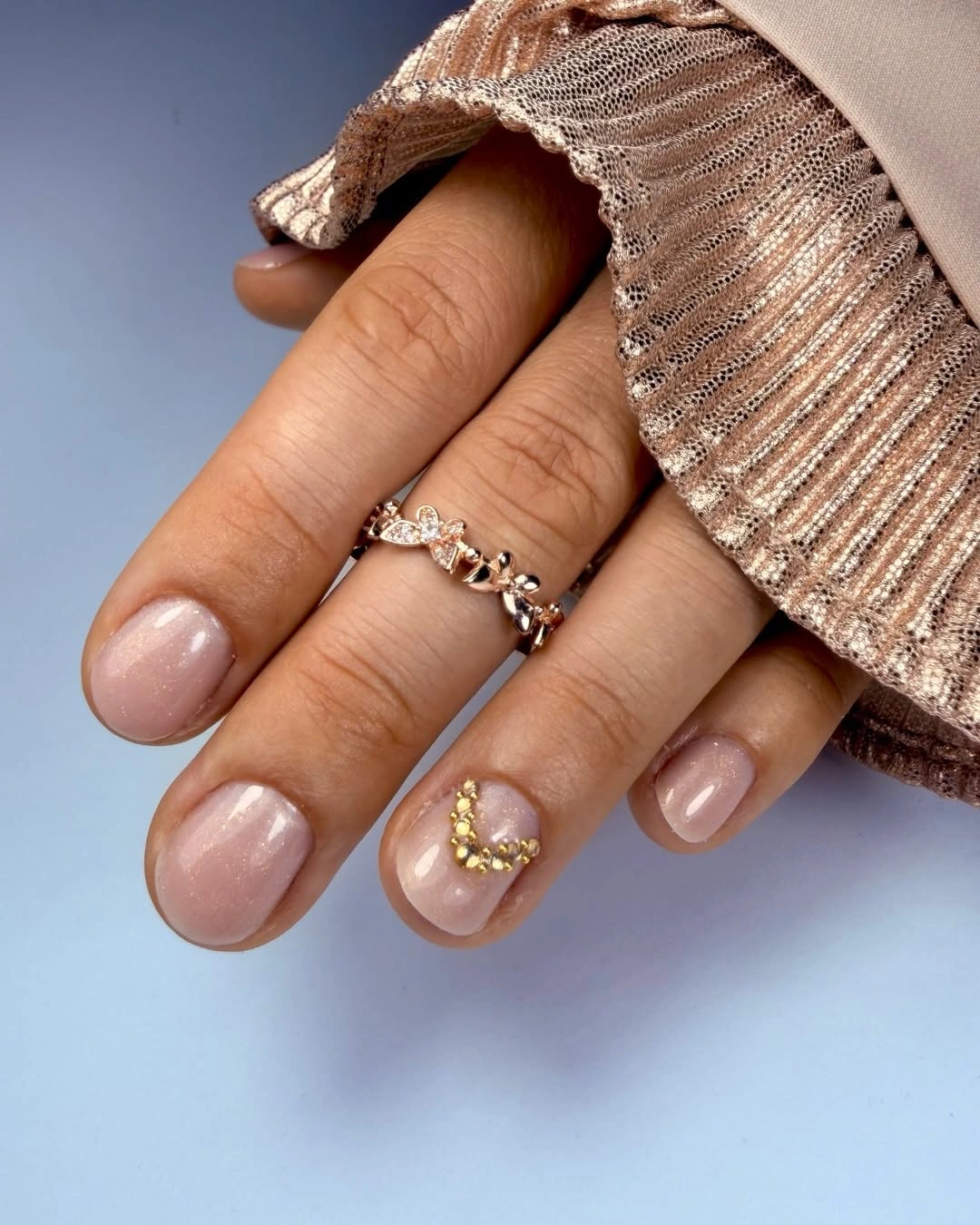 Short blush pink nails with one gold curved accent