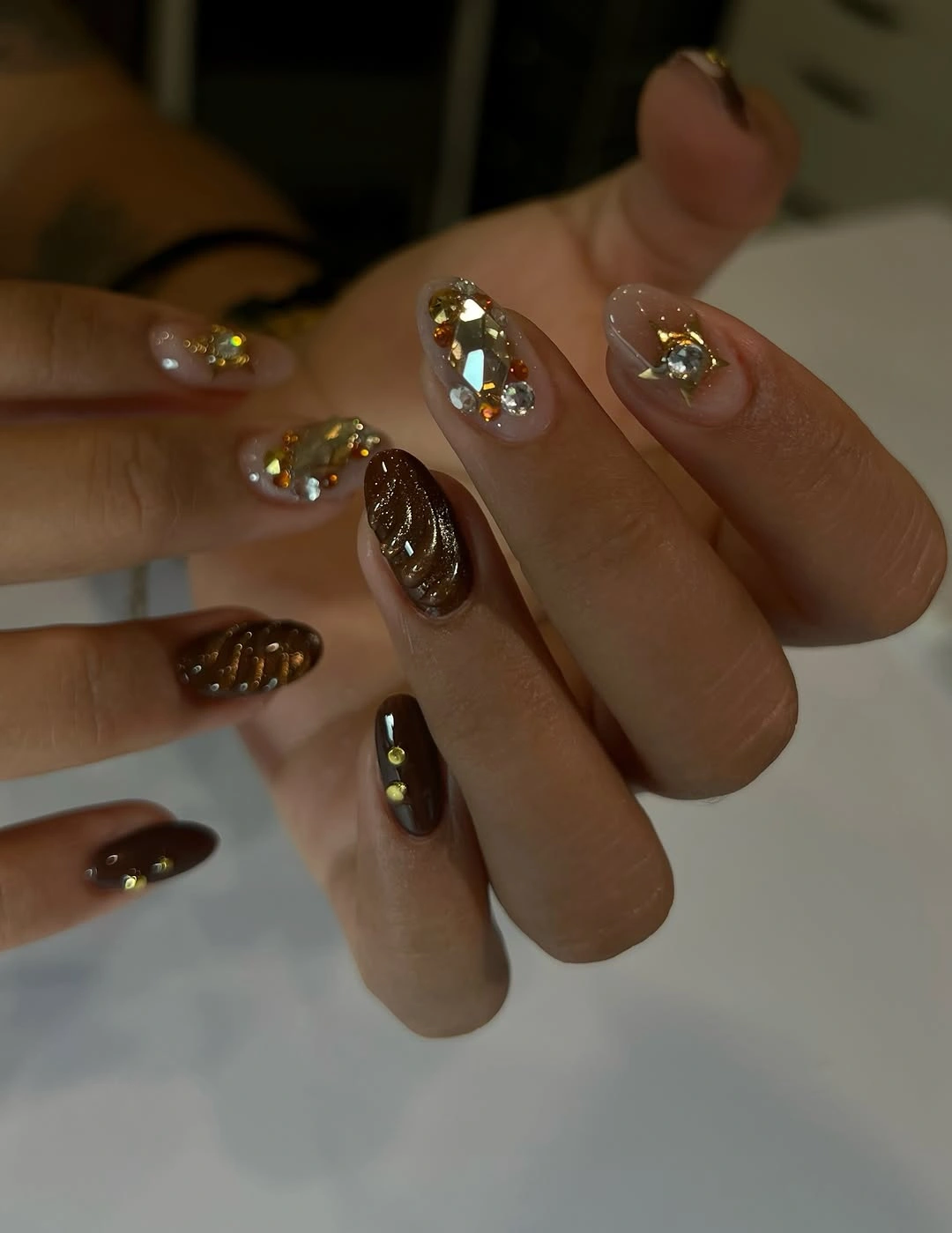 Dark chocolate and nude nails with small gold accents