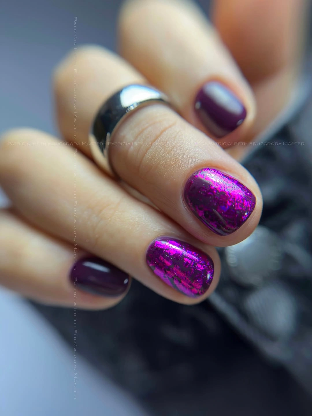 Short dark purple nails with reflective magenta accents