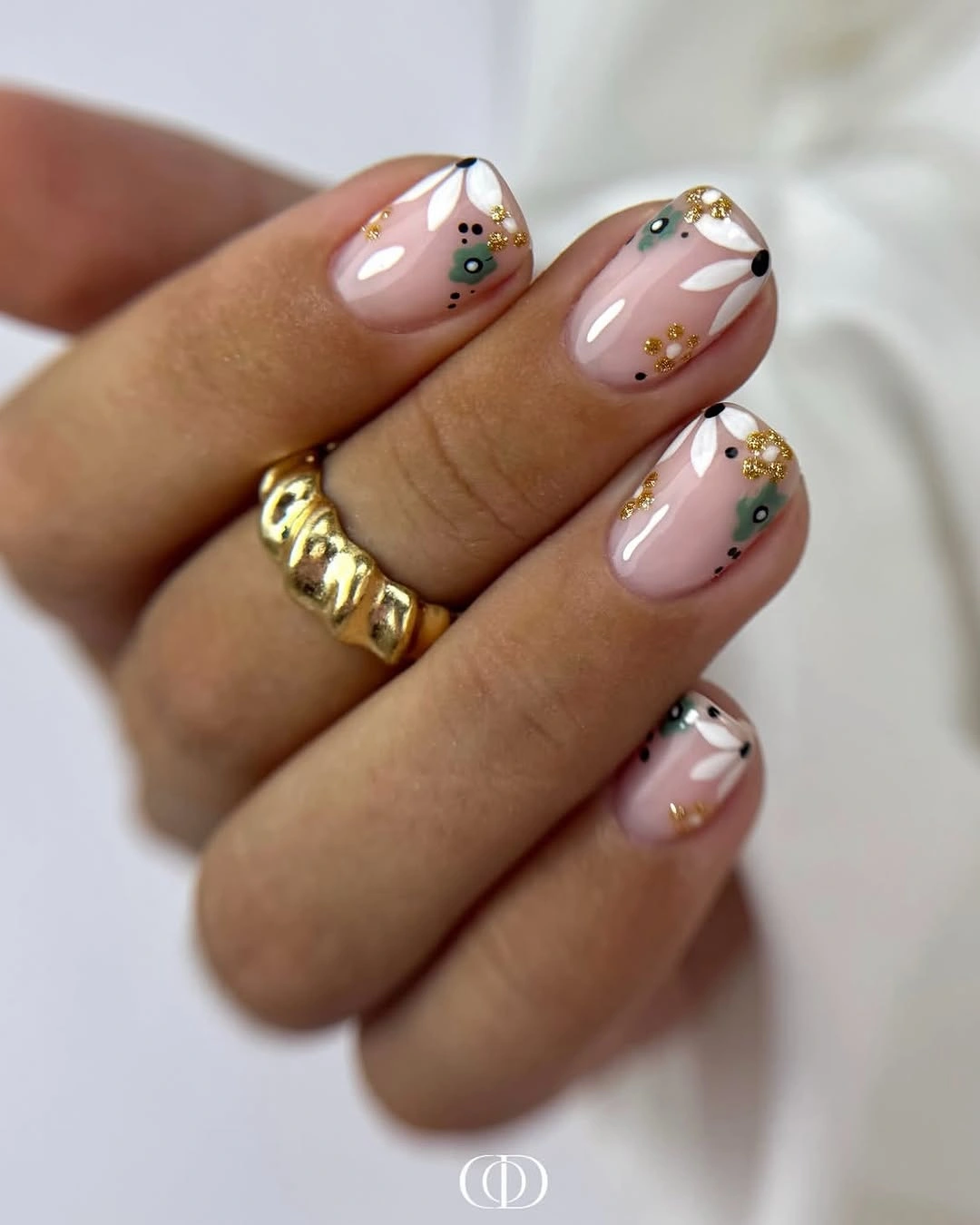 Glossy pink nails with black lines and small gold dots
