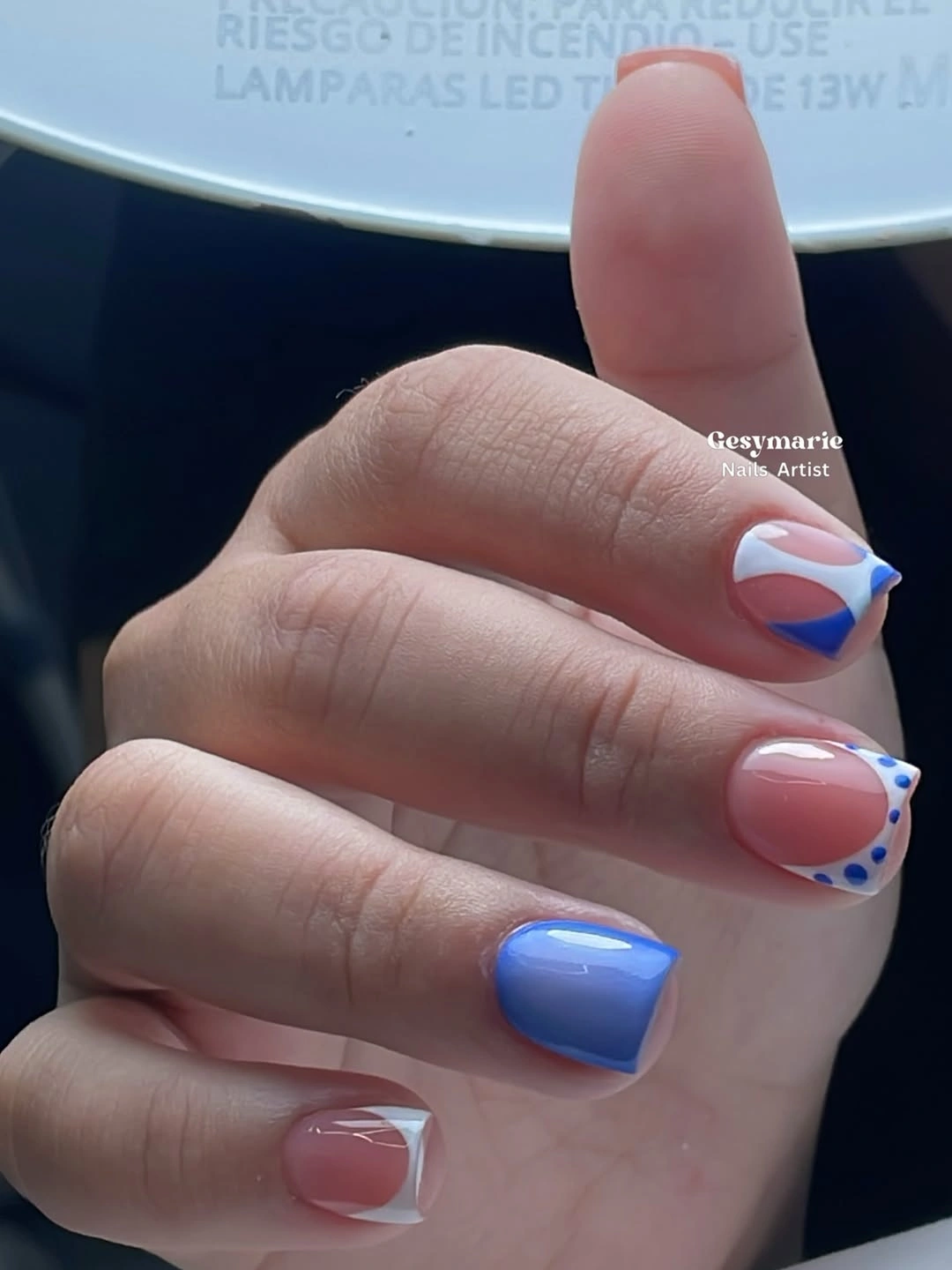 Short nails with blue tips, dots and curved accents