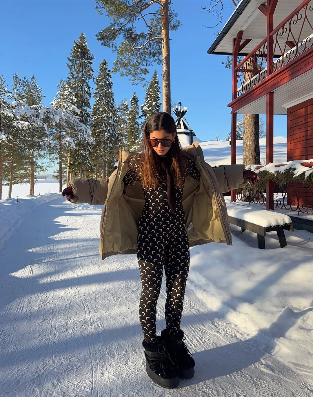 Olive puffer coat over black and white dotted outfit with black lace-up boots