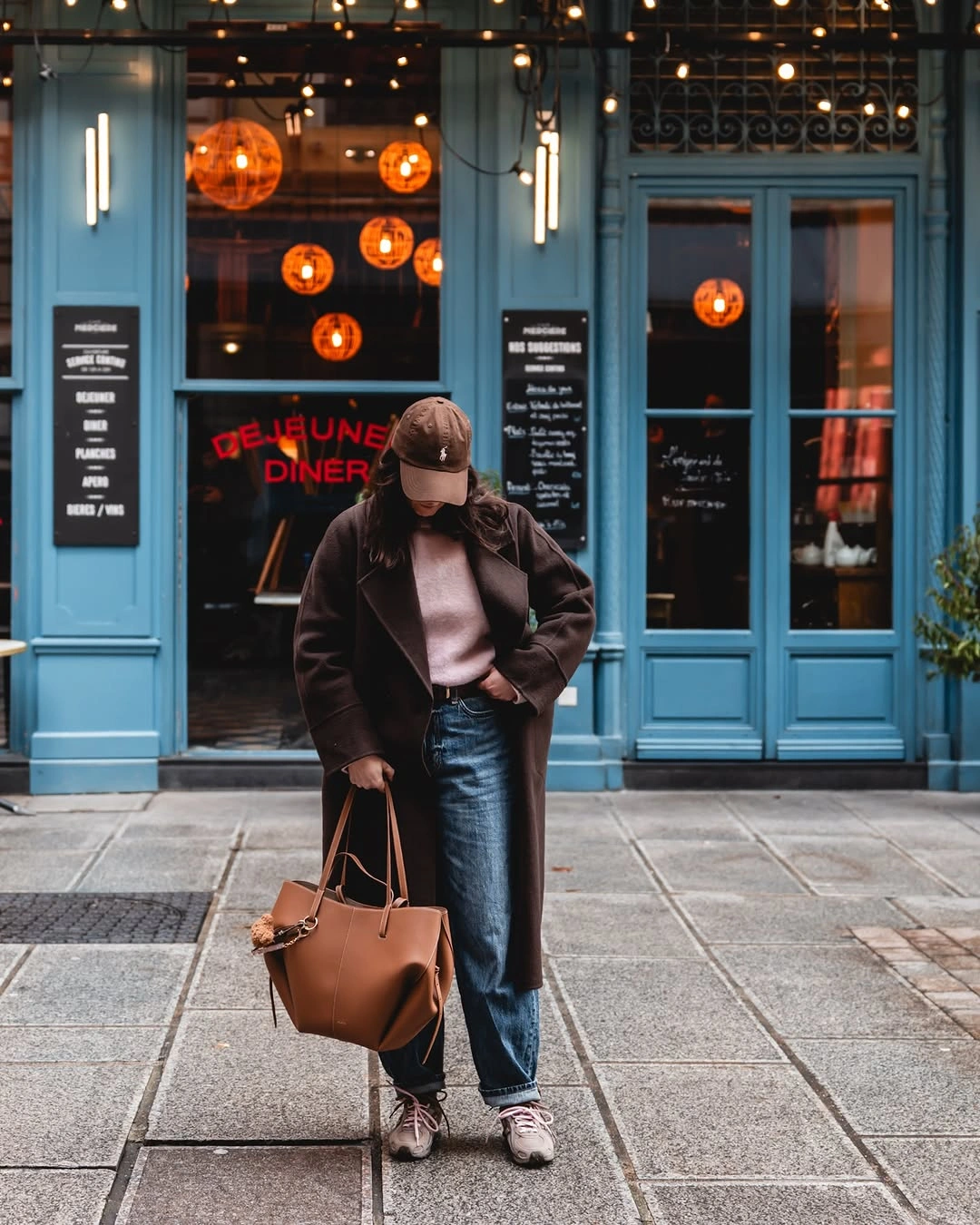 Brown textured jacket pink knit black leather-look pants and tan tote