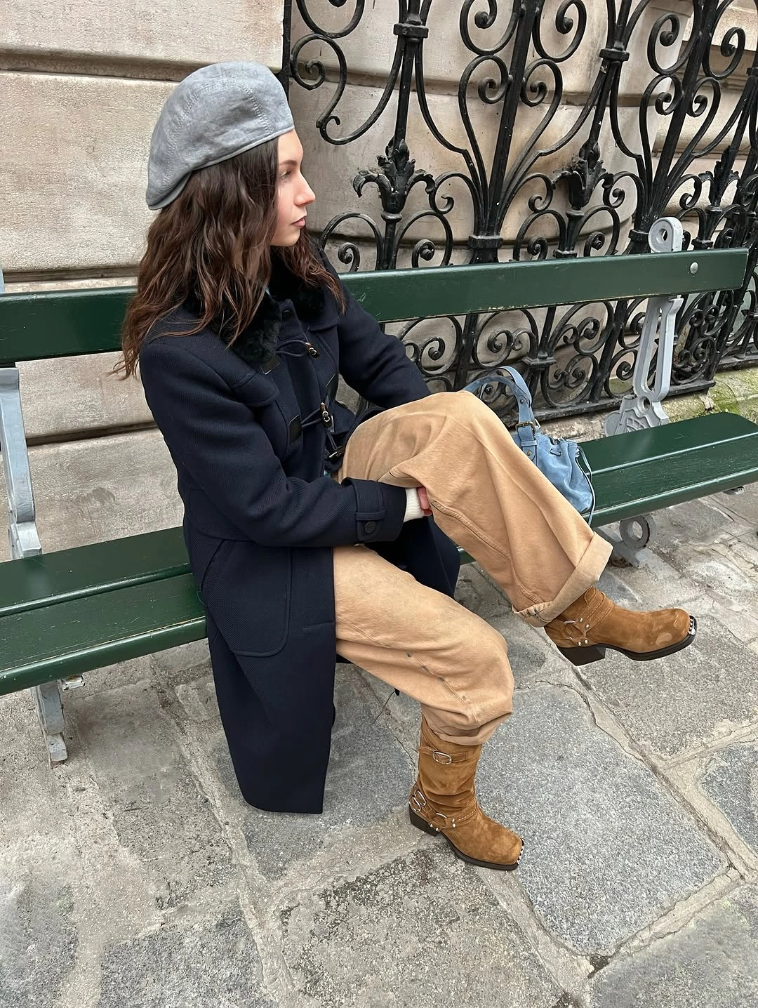 Navy duffle-style coat with tan cargo pants camel boots and gray beret
