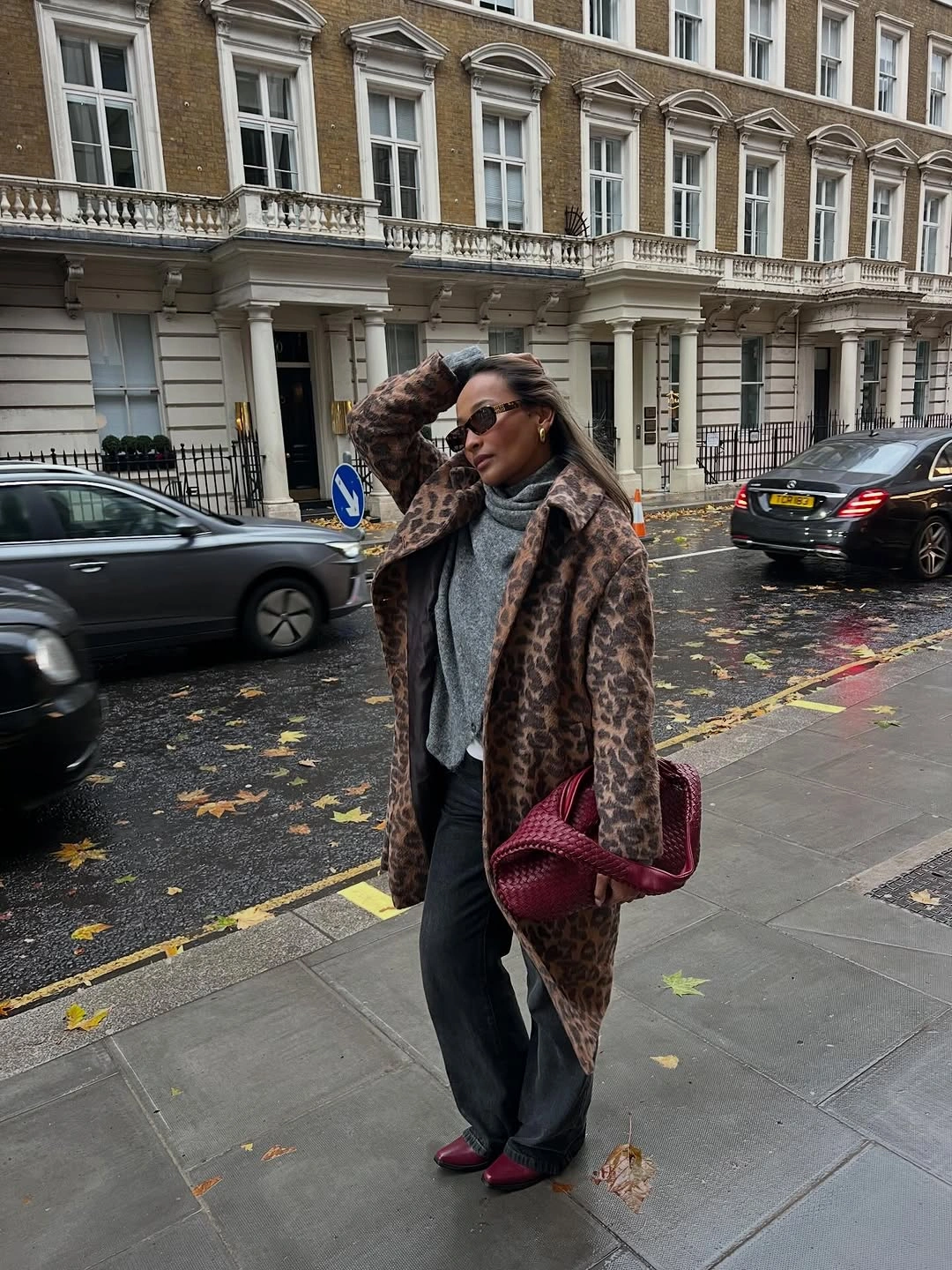 Brown patterned textured coat with gray scarf black trousers burgundy shoes and bag