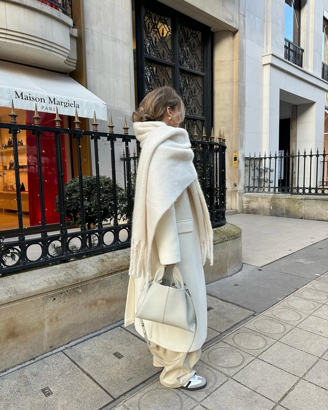 Cream coat and trousers with long white scarf large white handbag and sunglasses