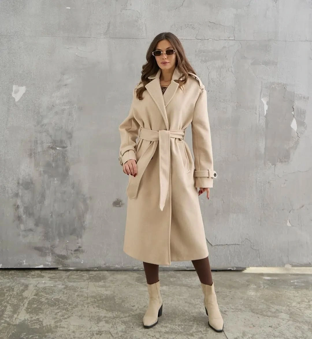 Cream belted wrap-style coat with brown leggings and ankle boots