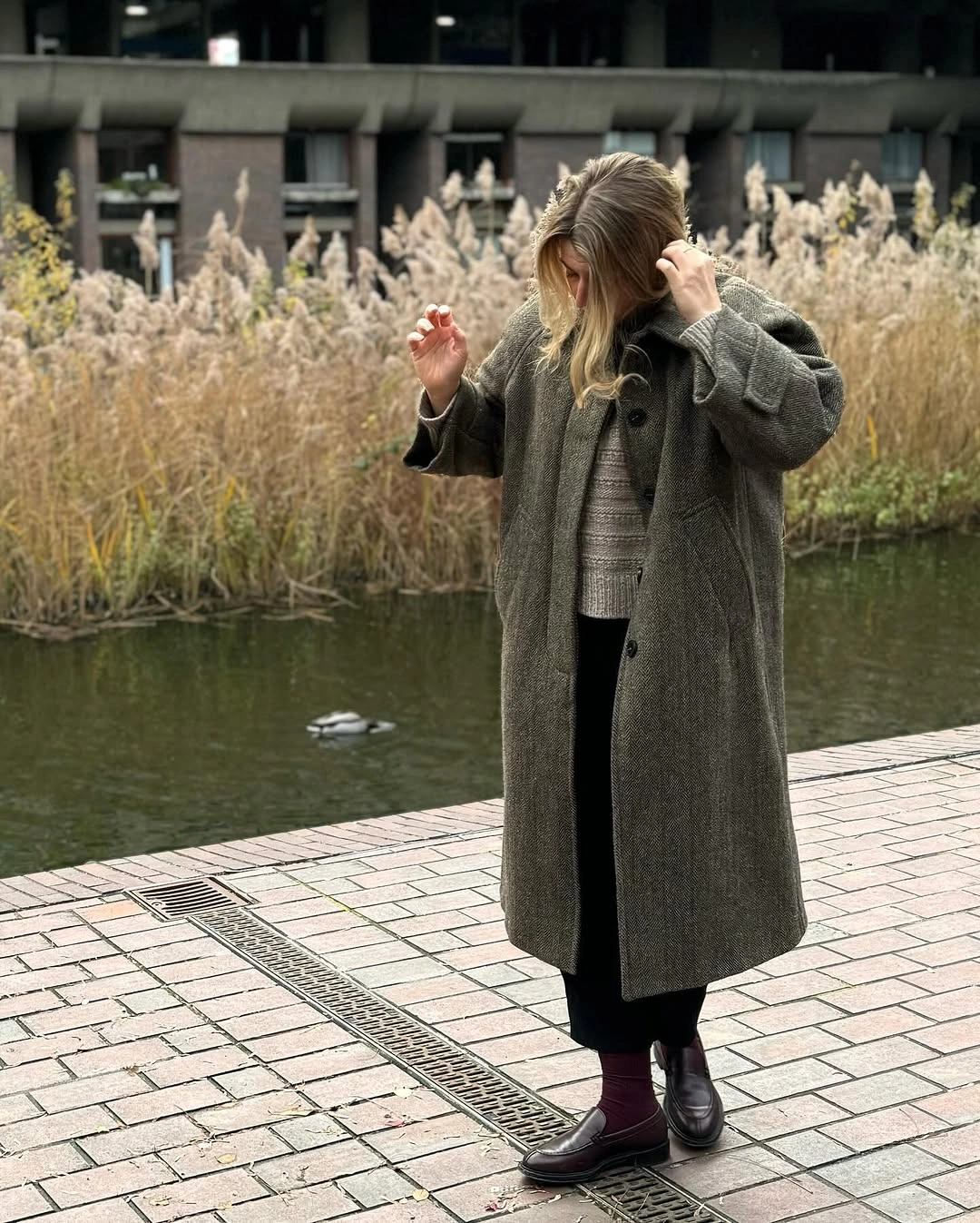 Gray textured long coat with striped sweater and wide trousers