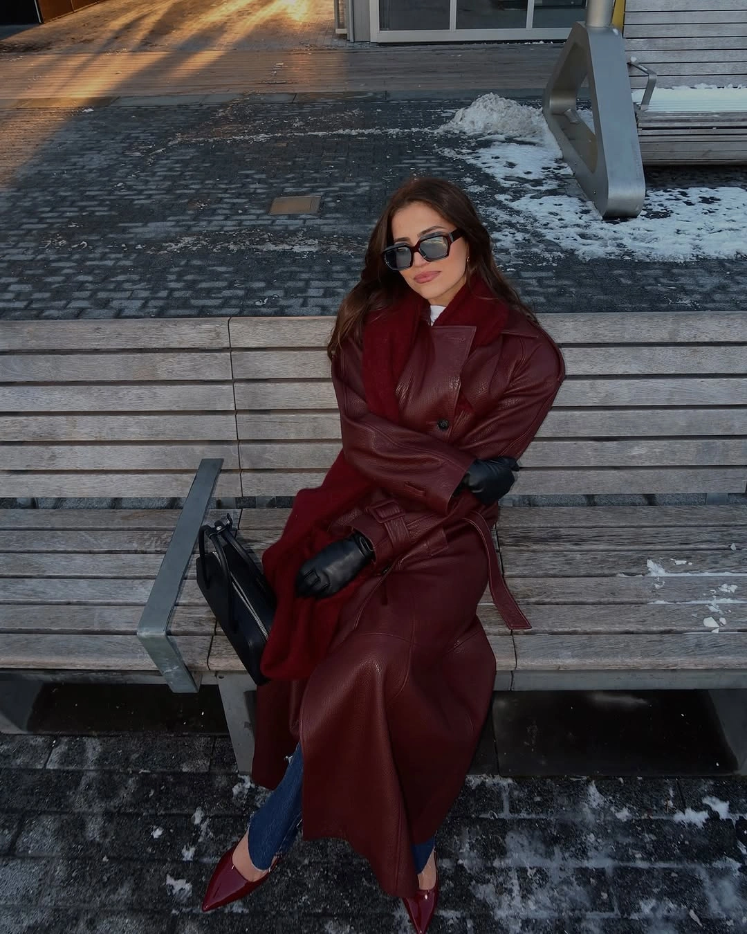 Belted burgundy leather-look coat with jeans and pointed shoes
