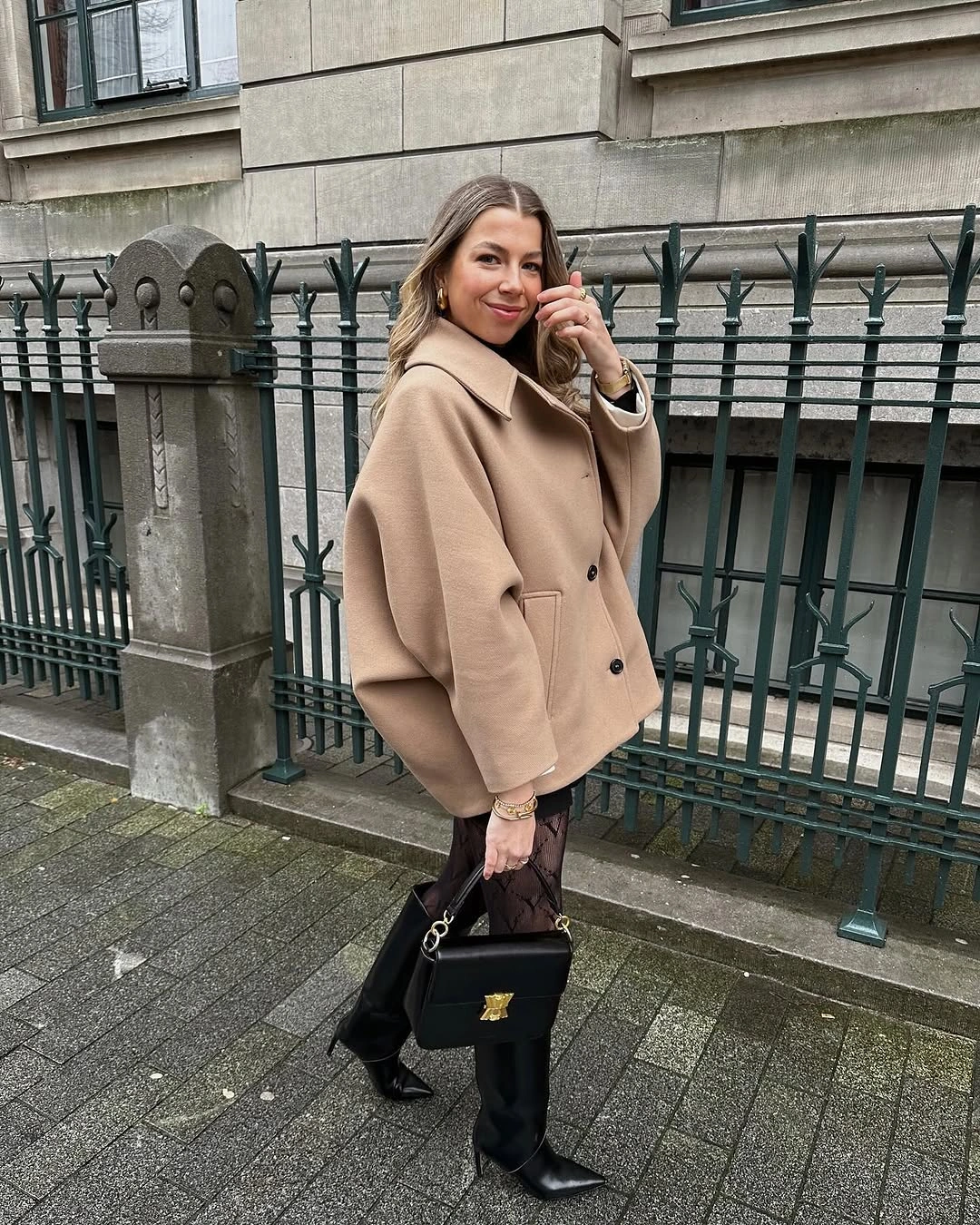 Oversized camel coat with patterned layer and black tall boots