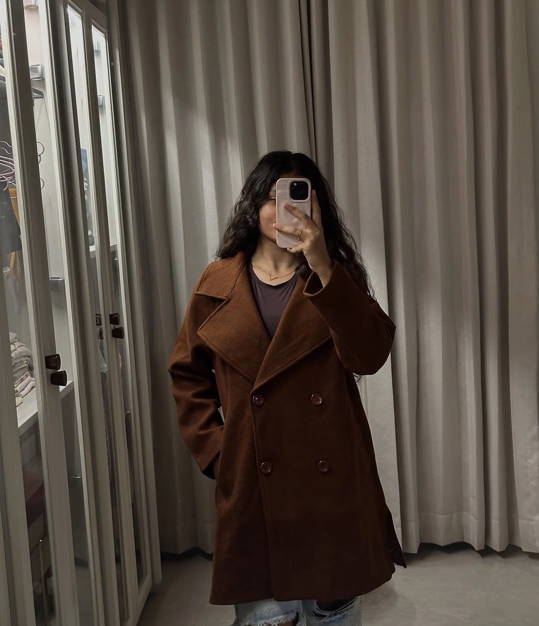 Brown double-breasted coat with dark top and light jeans