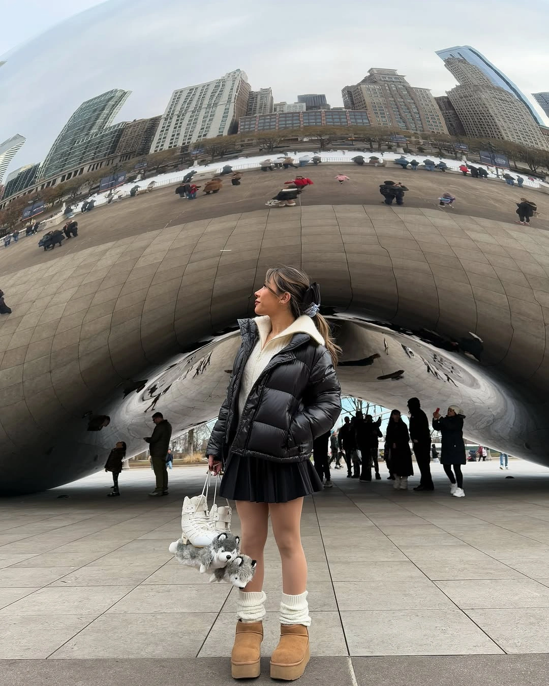 Black short puffer with white hood, pleated skirt and platform boots